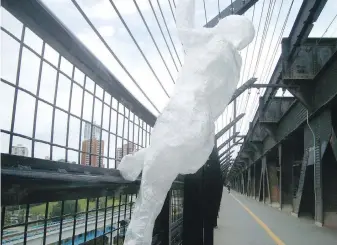  ?? CP ?? One of the human-like figures put on the fence on High Level Bridge in Edmonton on Sunday.