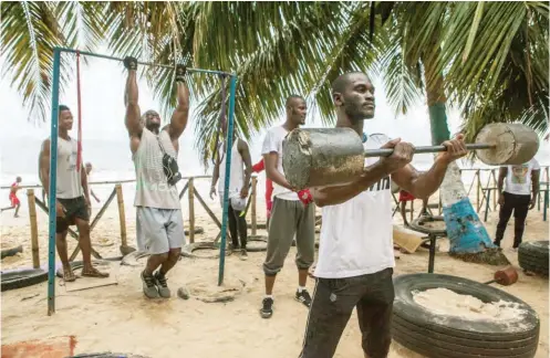  ?? Photo Credit: JANE HAHN FOR THE NEW YORK TIMES ?? Men exercising at the Tai Bo Gym on Lumley Beach