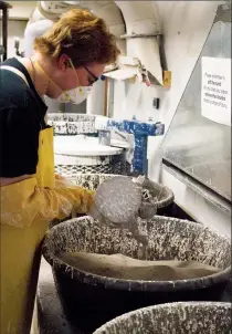  ?? Herald photo by Greg Bobinec ?? Andrea Ciuffa covers her bronze mould in layers of ceramic and sand before pouring in the extremely hot bronze, at the Taste of Bronze class at the University of Lethbridge.