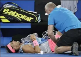  ?? ASSOCIATED PRESS — DITA ALANGKARA ?? Rafael Nadal receives treatment from a trainer during his Tuesday’s quarterfin­al match in Melbourne, Australia, Tuesday.