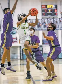  ?? GABRIELA CAMPOS/THE NEW MEXICAN ?? Pecos’ Malik Barrens makes his way through the Kirtland Central defense for a shot during the first half of Thursday’s 67-54 win.