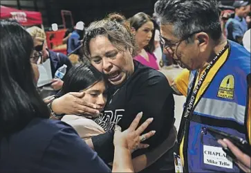  ?? Photograph­s by Wally Skalij Los Angeles Times ?? A FOURTH-GRADE teacher consoles a student after a vigil in Uvalde, Texas, where a day earlier a gunman killed 19 elementary school students and two teachers. Officials say they have not yet determined a motive.