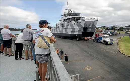  ?? WARWICK SMITH/STUFF ?? Manawatu¯ Marine Boating Club members watch preparatio­ns for The Beast’s launch from the clubhouse balcony.