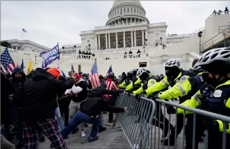  ?? AP Photo/Julio Cortez ?? Trump supporters try to break through a police barrier, on Wednesday at the Capitol in Washington.