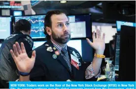  ??  ?? NEW YORK: Traders work on the floor of the New York Stock Exchange (NYSE) in New York City. As concern continues over the global economic impact from the Coronaviru­s, global stock markets fell. — AFP