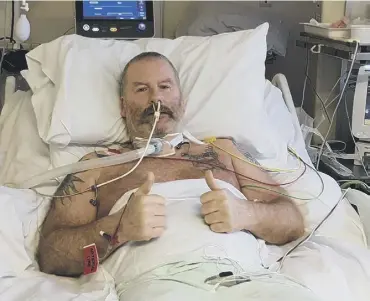  ??  ?? THUMBS UP: Paul Regan in his hospital bed