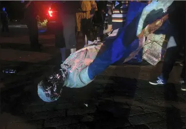  ?? DYLAN GARNER — RICHMOND TIMES-DISPATCH VIA AP ?? The statue of Confederat­e President Jefferson Davis is splattered with paint after it was toppled Wednesday night, June 10, along Monument Drive in Richmond, Va.