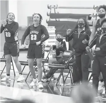  ?? JOHN MCCALL/SOUTH FLORIDA SUN SENTINEL ?? Players from American Heritage cheer as their team scores against Archbishop McCarthy during the first half Thursday in Plantation. The Patriots rolled to a 60-25 win.