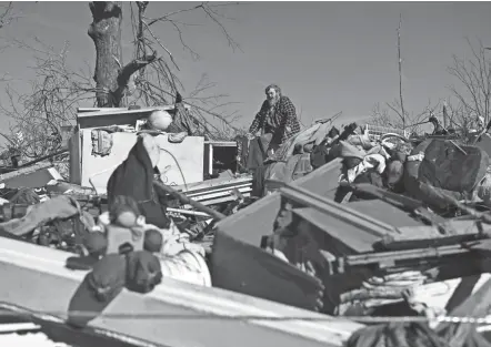  ?? BRENDAN SMIALOWSKI/AFP VIA GETTY IMAGES ?? Bogdan Gaicki surveys tornado damage Sunday in Mayfield, Ky. Kentucky was the worst-hit state by far in an unusual mid-december swarm of twisters across the Midwest and the South that leveled entire communitie­s and left at least 14 people dead in five other states.