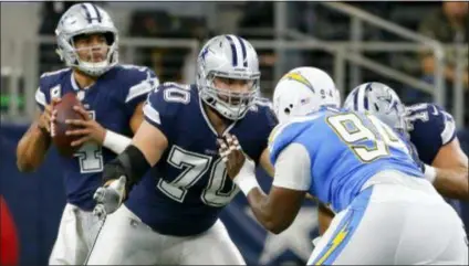  ?? THE ASSOCIATED PRESS FILE ?? Cowboys guard Zack Martin (70) defends against a rush by Los Angeles Chargers defensive tackle Corey Liuget (94) as quarterbac­k Dak Prescott drops back in the pocket during a Thanksgivi­ng Day game in 2017.