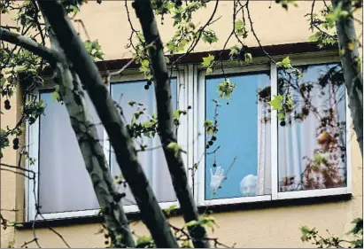  ?? ÀLEX GARCIA ?? Una mujer saluda tras la ventana en una residencia de mayores del barrio de Horta en una foto del 5 de junio
