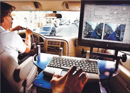  ?? JEFF CHIU/ AP ?? A driver for Tele Atlas, one of MapQuest’s data-collecting partners, drives a mapping van in San Francisco this month, while another employee whose hand is on the laptop’s keyboard tends to data gathering. Wireless has given Internet-based mapping...