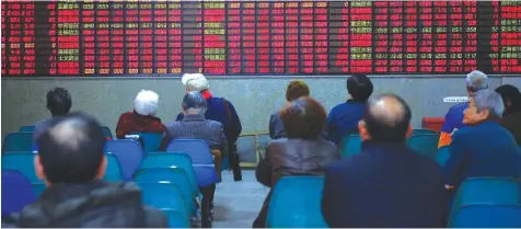  ?? — Reuters ?? Investors look at an electronic board showing stock informatio­n at a brokerage house in Shanghai.