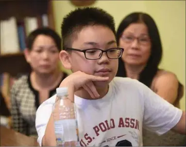  ?? BILL UHRICH - FOR MEDIANEWS GROUP ?? Vincent Bui, 11, talks Tuesday in St. Paul’s Roman Catholic Church about the events that led to the death of his father, Thanh Bui, on Monday in Atlantic City. Thanh Bui died after trying to save Vincent, who got caught in a riptide. With him are Thanh’s wife, Diep Thi Huynh, left, and sister Tam Bui.