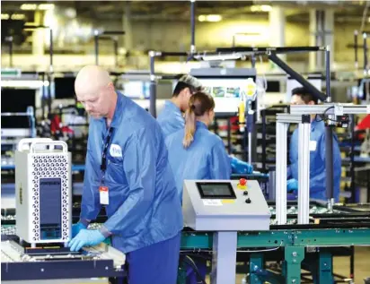  ?? AP PHOTO/ EVAN VUCCI ?? Workers are shown at an Apple manufactur­ing plant in Austin, Texas, last year. American factories slowed for the third consecutiv­e month in May.