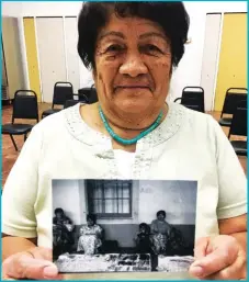  ??  ?? Jeweler Maria Susanna Lovato shows off a photo of a past Indian Market.