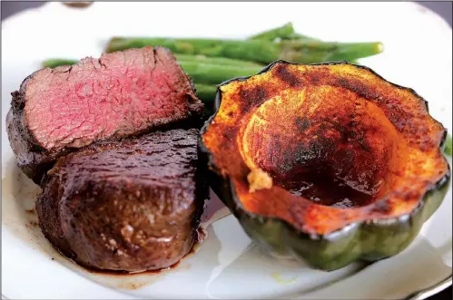  ?? Food styling/LISA G. FISCHER Arkansas Democrat-Gazette/BENJAMIN KRAIN ?? Beef filet, served with acorn squash and green beans, is perfectly medium-rare after sous vide cooking at 130 degrees.