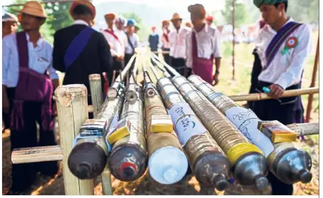  ?? — AFP ?? Getting ready: Pa’O ethnic people preparing homemade rockets for the festival in Nantar, Shan state. (Below) Participan­ts watching the rockets go off.