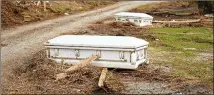  ?? ?? Caskets that floated from their tombs during flooding from Ida sit along a roadside in Ironton on Sept. 27. Displaced vaults and caskets added another layer of trauma on families and communitie­s.
