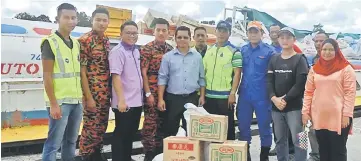  ??  ?? Mackos (centre) with officers who sent the aid to the flood victims in Tutoh region.