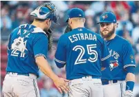  ?? MICHAEL DWYER/THE ASSOCIATED PRESS ?? Tuesday starter Marco Estrada gets advice from two catchers — Luke Maile and part-time third baseman Russell Martin.