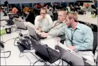  ?? NWA MEDIA/SAMANTHA BAKER ?? Mike Rutherford (from left), Myles Bennett and Keith Dye, all with Wal-Mart Stores Inc., talk Monday about security and safety plans for stores in the path of Hurricane Sandy in Wal-Mart’s Emergency Operations Center in Bentonvill­e.