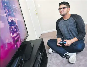  ?? MICHAEL S. WILLIAMSON/ THE WASHINGTON POST ?? Danny Izquierdo, who is 22, unemployed and living with his parents, has a passion for video games.