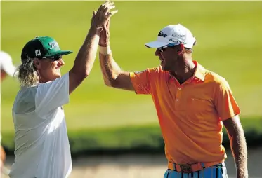  ?? Jared Wickerham/ Getty Images ?? Charley Hoffman, left, and Canadian Graham DeLaet high-five after Hoffman made a chip shot from the bunker during the final round of the 2013 Travelers Championsh­ip on Sunday.