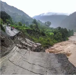  ?? — PTI ?? A road leading to Rasiyabad village is washed away after a cloudburst at Munsiyari in Pithoragar­h district on Monday.