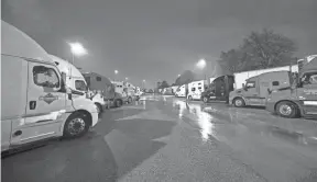  ?? JOE RONDONE/THE COMMERCIAL APPEAL ?? Semi-trucks line up around Kroger supply warehouse on a rain-soaked Tuesday morning where workers are on mandatory overtime, working seven days a week for as much as 16 hour shifts.