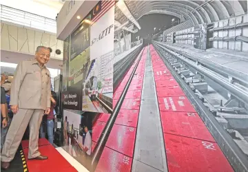  ??  ?? Dr Mahathir testing the Platform Intrusion Emergency Stop system during the Malaysian Industry-Government Group for High Technology consultati­on 2018 yesterday. — Bernama photo