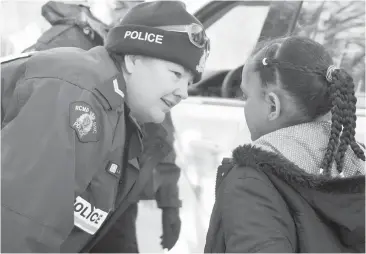  ??  ?? An RCMP officer comforts a young asylum claimant who crossed the border into Canada from the United States last week near Hemmingfor­d, Que. Sen. Colin Kenny writes that the RCMP is not getting the support it needs for its many difficult tasks.