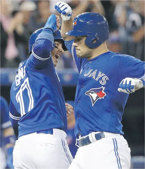  ?? TOM SZCZERBOWS­KI / GETTY IMAGES ?? Luke Maile is congratula­ted by Blue Jays teammate Ryan Goins after hitting a two-run homer Wednesday.