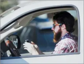  ?? ASSOCIATED PRESS FILE PHOTO ?? A man uses his cell phone as he drives through traffic in Dallas in 2013.