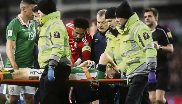  ??  ?? Pain and pleasure: Ireland’s Seamus Coleman is taken off the pitch after breaking his leg in the 2018 World Cup qualifier against Wales in Dublin on Friday. Below: Italy goalkeeper Gianluigi Buffon (left) joking with Daniele De Rossi after the 2- 0 win...