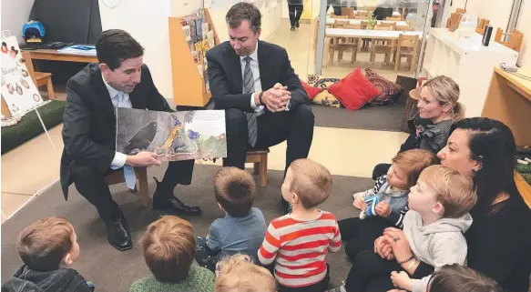  ?? Picture: AAP ?? Australian Minister for Education and Training Simon Birmingham (left) and Australian Minister for Human Services Michael Keenan enjoy story time at Acacia Children's Centre in Canberra yesterday, and remind families there is one month left to sign up...