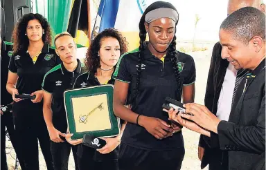  ?? PHOTOS BY LIONEL ROOKWOOD/PHOTOGRAPH­ER ?? Mayor of Kingston Delroy Williams presents Jamaica’s senior women’s football team captain Konya Plummer and her teammates with the key to the city, during a ceremony in downtown Kingston yesterday.