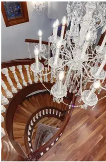  ??  ?? The original staircase was dated and in desperate need of a refresh. New risers and walnut treads were installed while the oak railing and newel posts were re-stained with new spindles added. To capture a comprehens­ive portrait of updated appeal, a New Orleans-style chandelier with Fleur de Lis design and matching wall sconces portray the elegant side of traditiona­l styling.