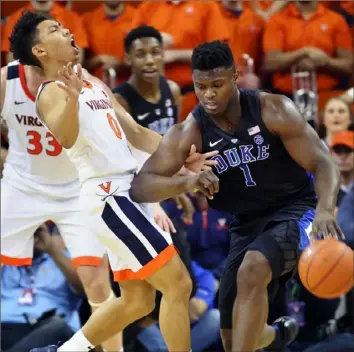  ?? Ryan M. Kelly/Getty Images ?? Virginia’s Kihei Clark, left, attempts to defend Duke’s Zion Williamson in a key ACC game Saturday in Charlottes­ville, Va. No. 2-ranked Duke defeated No. 3 Virginia, 81-71.