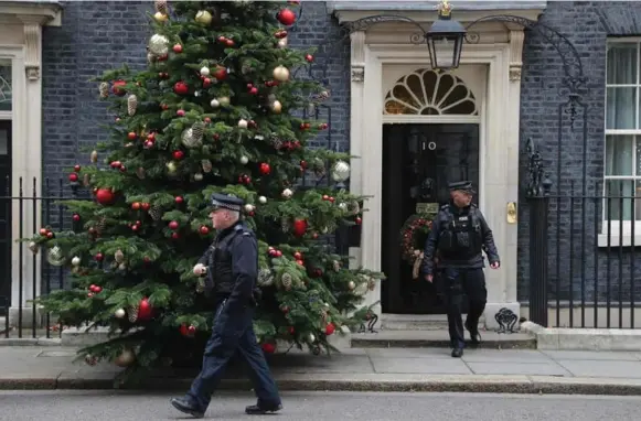  ?? DANIEL LEAL-OLIVAS/AFP/GETTY IMAGES ?? Police officers exit 10 Downing Street, the home and office of British prime ministers, on Wednesday. Prosecutor­s say the planned attack was to begin with a bombing of the security gates.