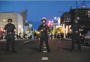  ?? Photograph­s by Robert Gauthier Los Angeles Times ?? LAPD officers lined up May 28 on Grand Avenue as protesters, many with Black Lives Matter, gathered.