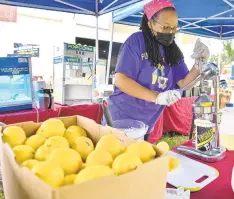  ??  ?? ABOVE: Kelli Petty squeezes lemons for lemonade at her Fun Stuff 4 Kids food concession.