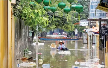  ??  ?? A woman wades along submerged by Typhoon Damrey houses in the Unesco heritage ancient town of Hoi An, Vietnam. — Reuters photo