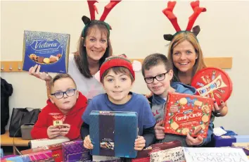  ?? 291118burn­side_05 ?? Chocs away Fergus MacKinnon, Finley Redmond Burns, Samuel Kelly. Back Row: Linda Phillips and Moira Redmond Burns at the Burnside chocolate tombola