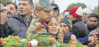  ?? AP ?? JCO Madan Lal Choudhary’s son Ankush Choudhary consoles his mother during former’s funeral in Kathua on Monday. The JCO was killed in Saturday's militant attack.