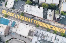  ?? JOHN MINCHILLO/AP ?? A Black Lives Matter sign is shown last year in New York. A report says donations to racial and social justice causes ticked up to 16% of American households in 2020.