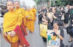  ?? — Reuters photo ?? Well-wishers offer alms to Buddhist monks to mark the first anniversar­y of Bhumibol’s death at the Siriraj Hospital in Bangkok.