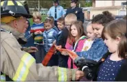  ?? PHOTO BY VALERIE HAVAS/ULSTER BOCES COMMUNITY RELATIONS ?? Woodstock Firefighte­r Evan Holland shows Woodstock Elementary School students how a fire hose works during the school’s celebratio­n of National Fire Prevention Week.