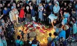  ??  ?? People lay flowers and place candles around the star of French-Armenian singer Charles Aznavour at the square named after him in Yerevan. — AFP