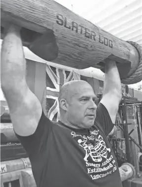  ?? EAGLE-GAZETTE JEFF BARRON/ ?? The Slater family announced the closing of Slaters Hardware next month at 1141 N. Memorial Drive in the Plaza Shopping Center. Steve Slater is shown here performing a log press with a 150-pound log in this Eagle-gazette file photo as the store also sells strength-training equipment.